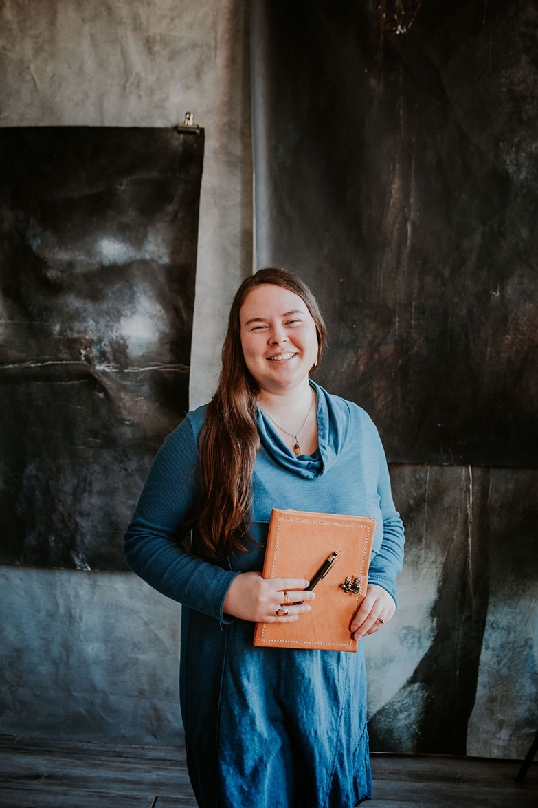 A photo of Amber holding a pen and notebook