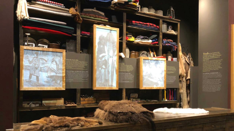 various items from the voyageur days including animal pelts, articles of clothing and blankets.