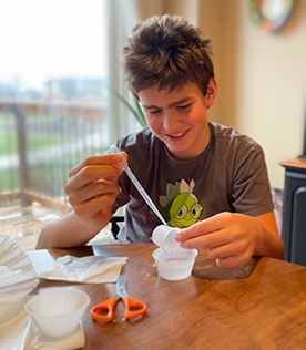 A student does an experiment with plastic cups and a dropper